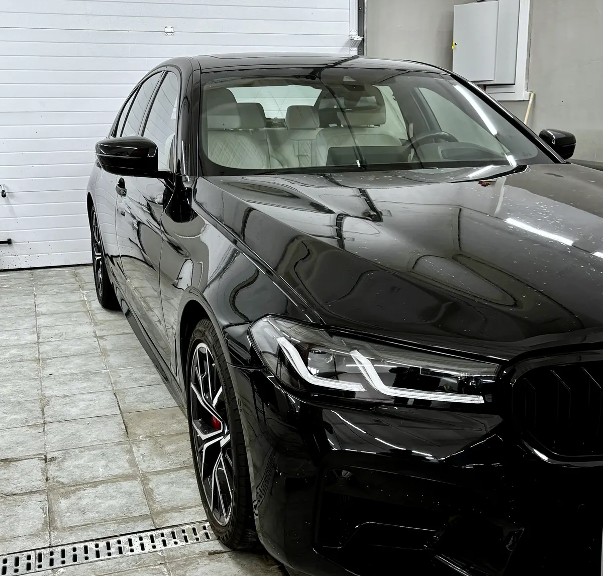 Чёрный BMW M5 в боксе студии